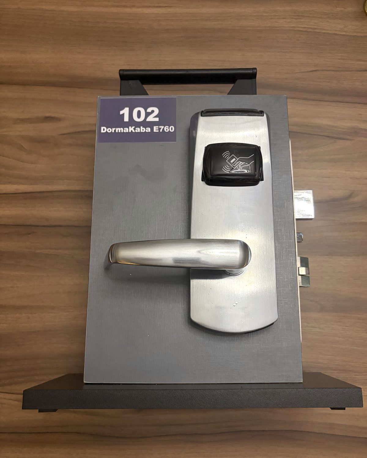 Amostrador 102: fechadura DormaKaba E760 convertida, com leitor RFID por aproximação no visor frontal.